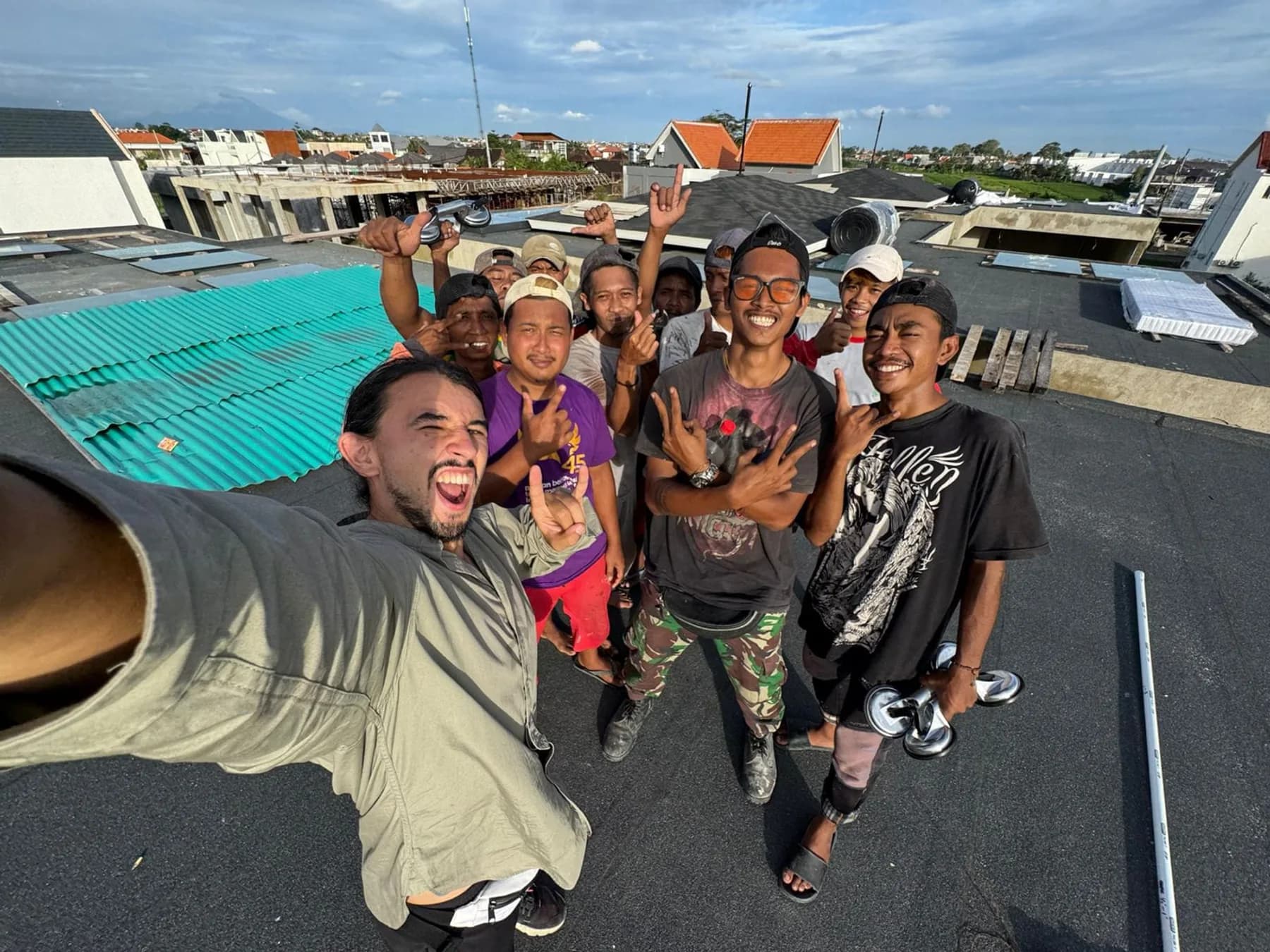 Kadek's construction crew smiling on a rooftop at a Bali building site